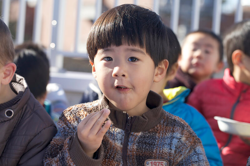 美味しそうにお餅を頬張る園児