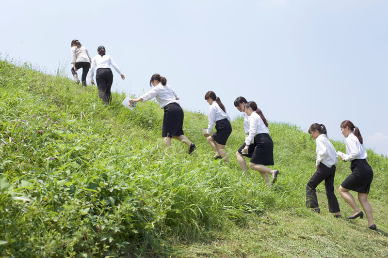 土手を登る学生たち