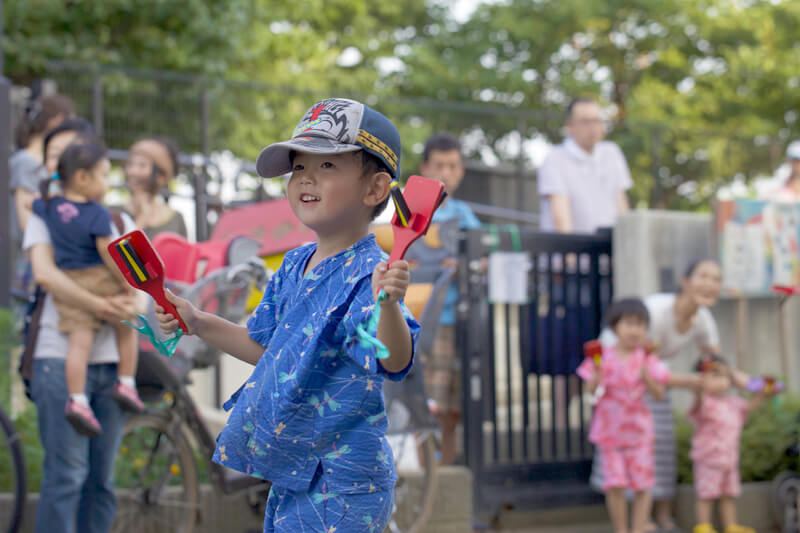 鳴子を両手に踊る園児