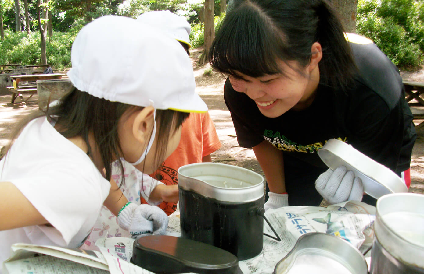 飯盒でお米を炊く学生と子ども