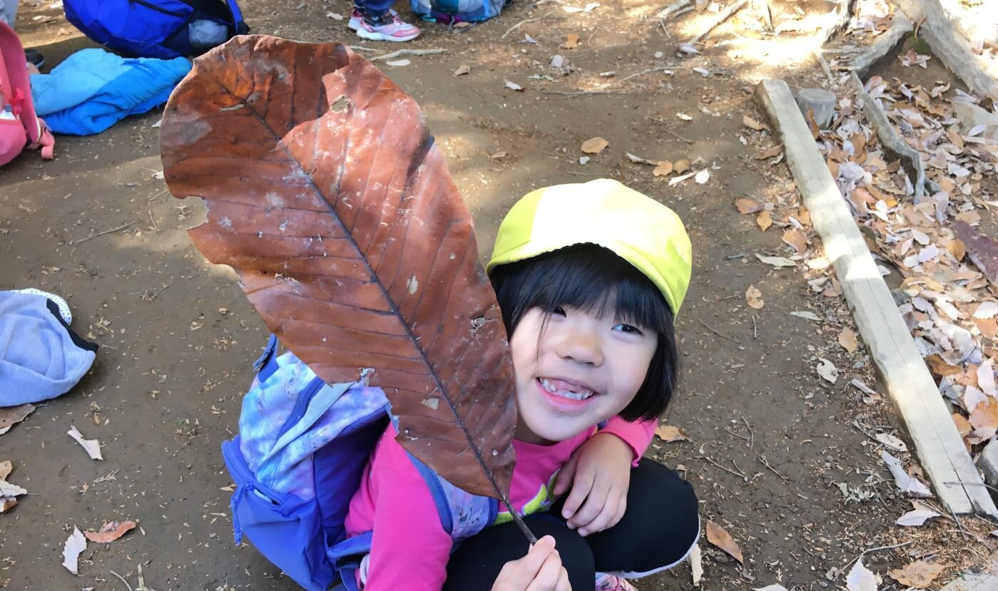 葉っぱを見せる子ども