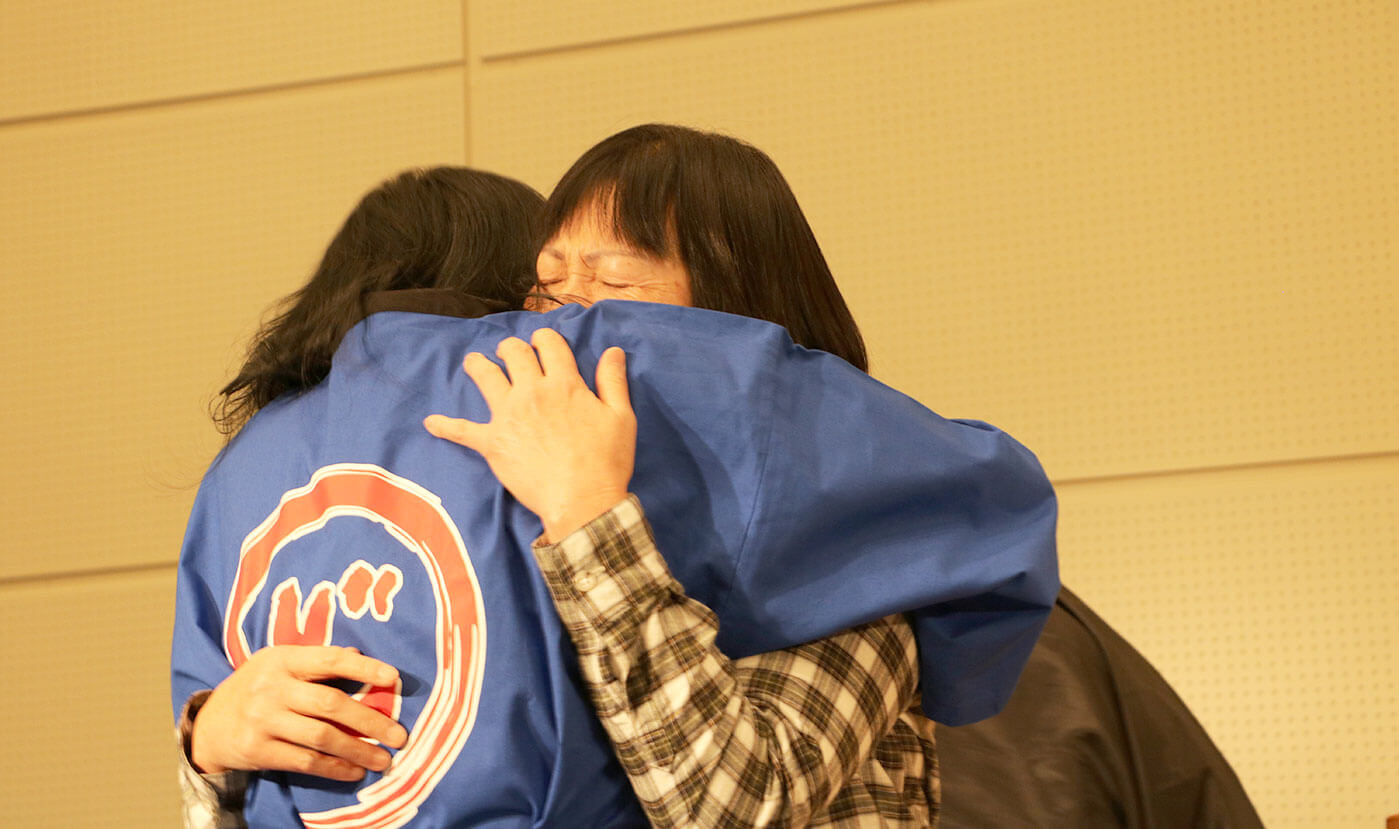 感激して安永と抱き合う受賞者