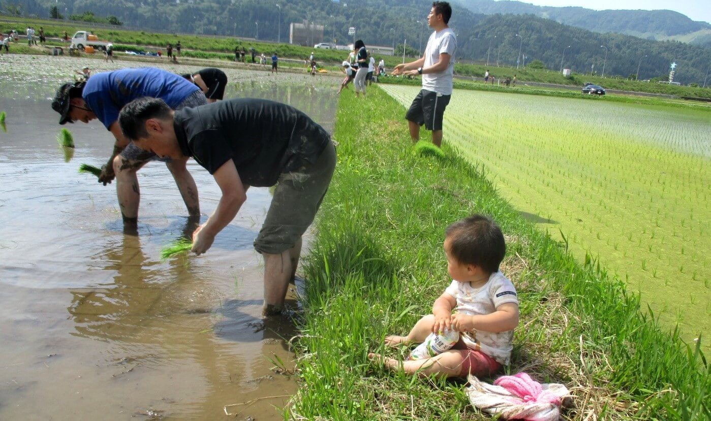 あぜ道で休憩する子ども