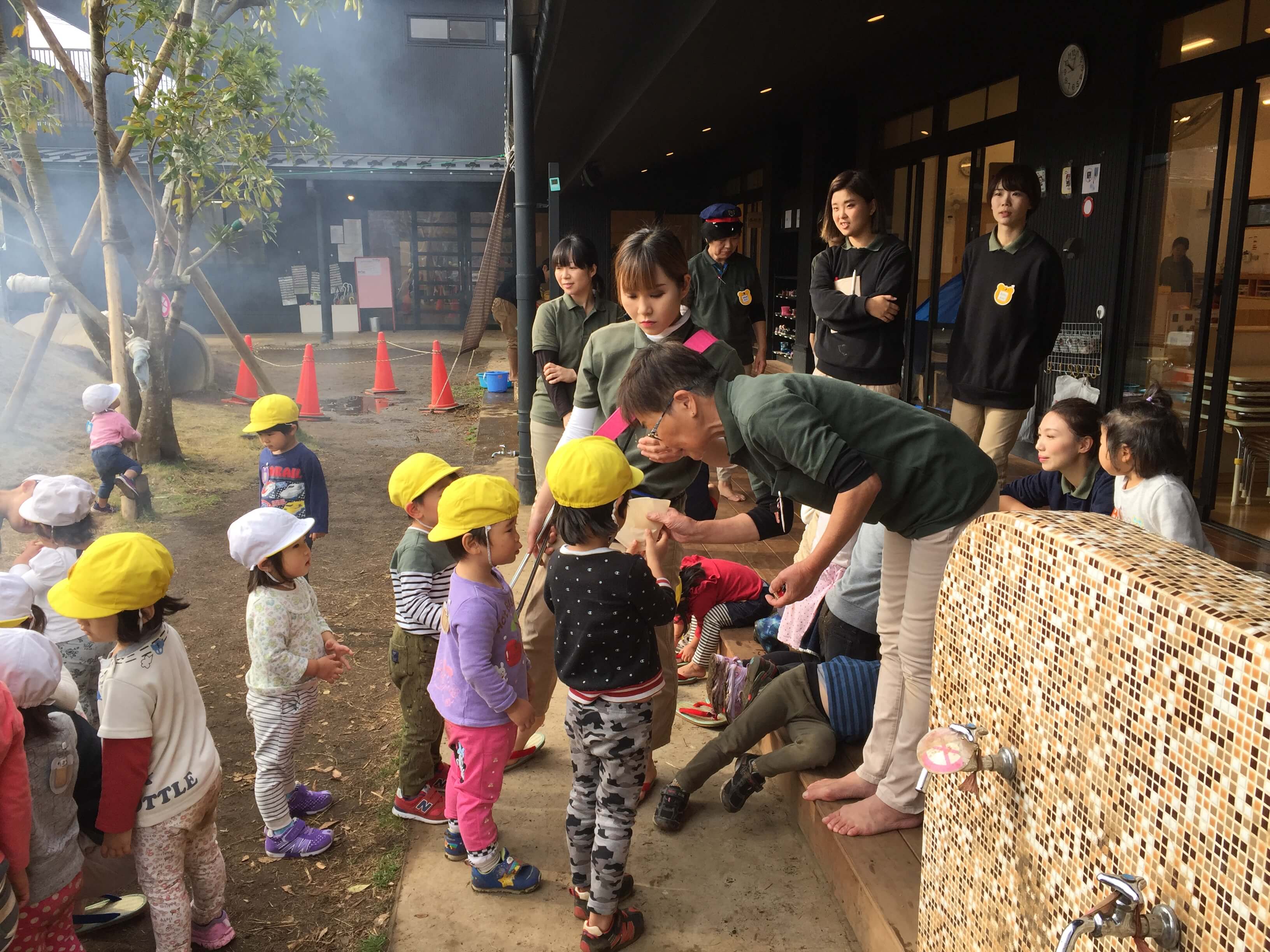 お煎餅の焼き具合をチェックする岡田園長と園児