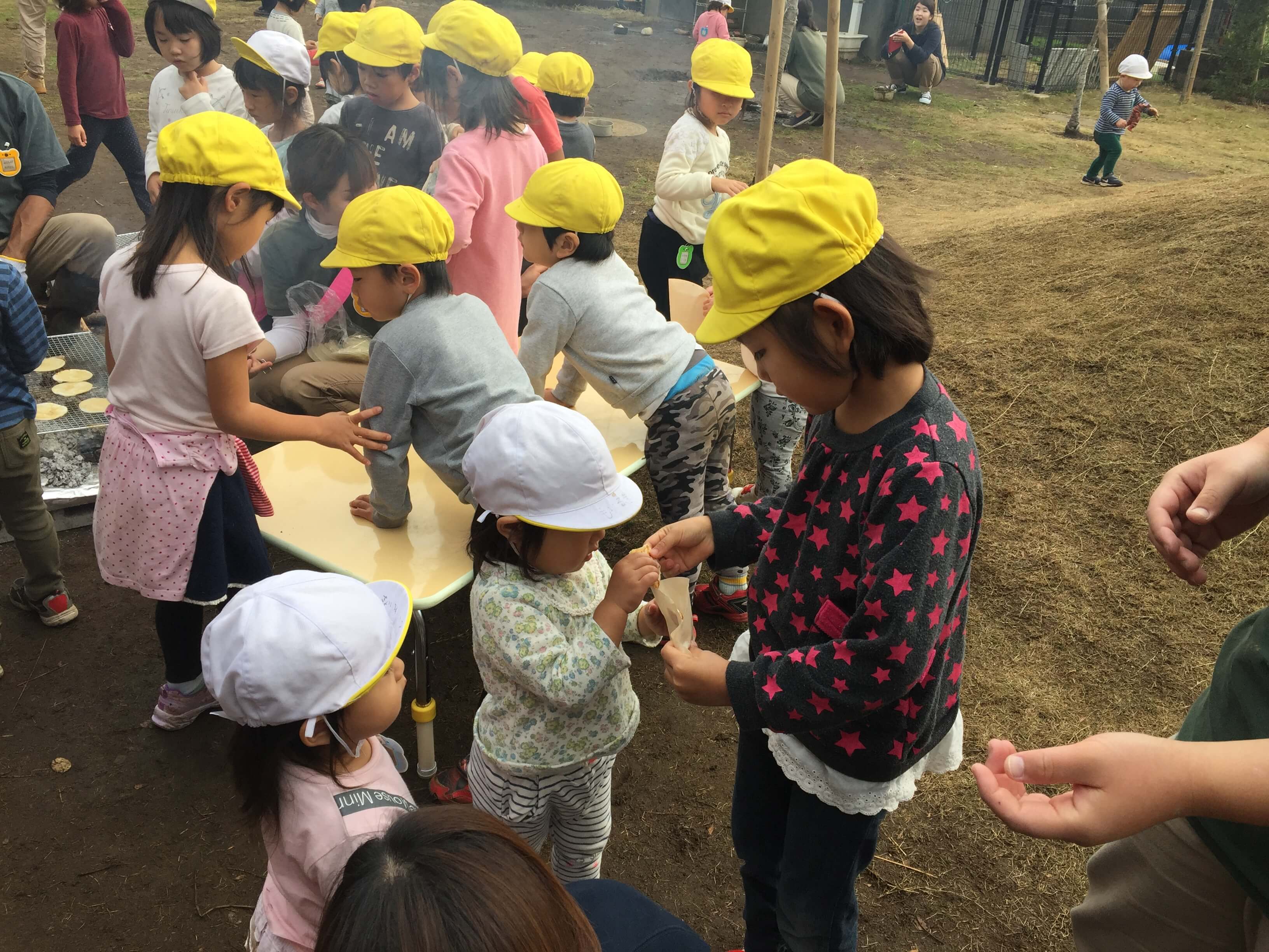 小さい子にお煎餅を配る年長児