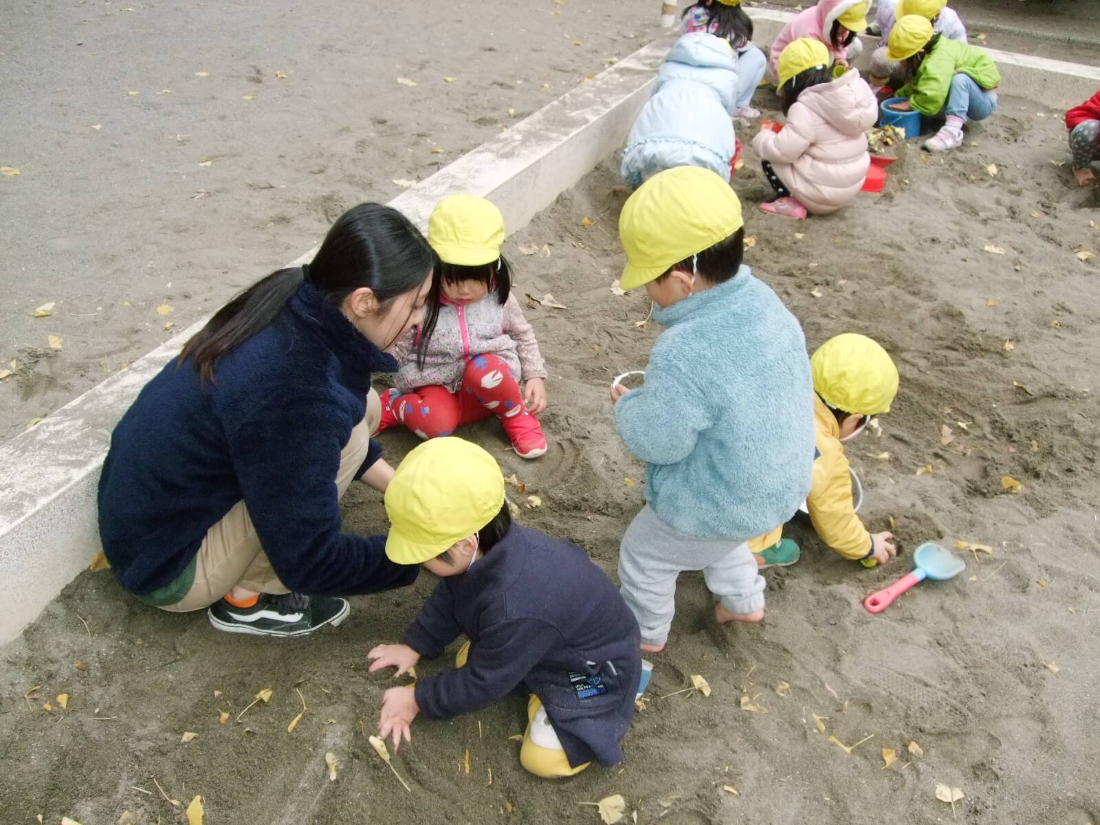 園児と砂遊びをする橋本さん