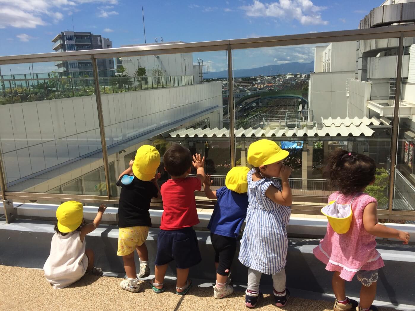 屋上から電車に手を振る子どもたち