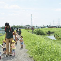 川沿いを散歩する園児と保育士たち