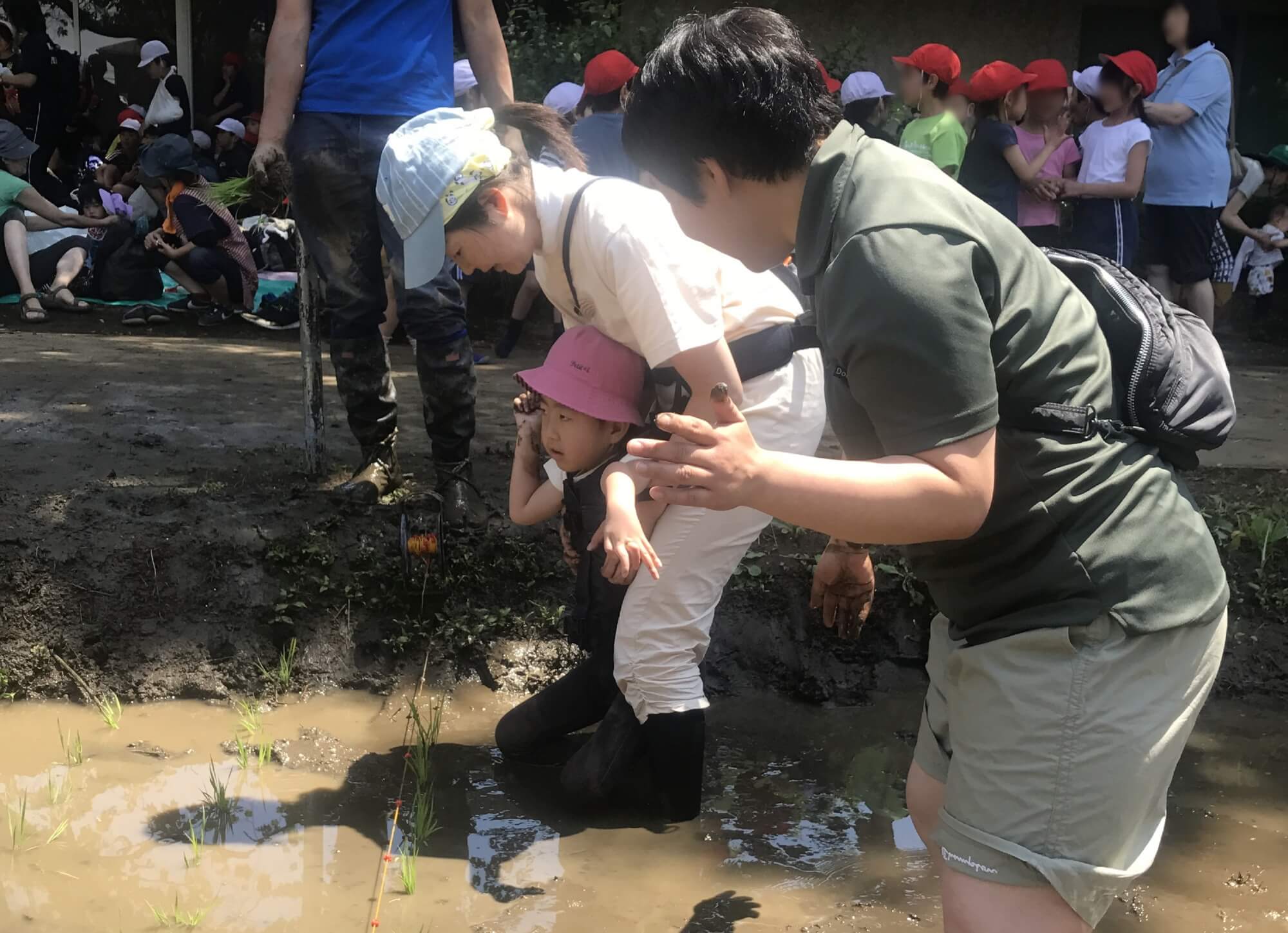 お母さんに支えられて泥の感触を感じる