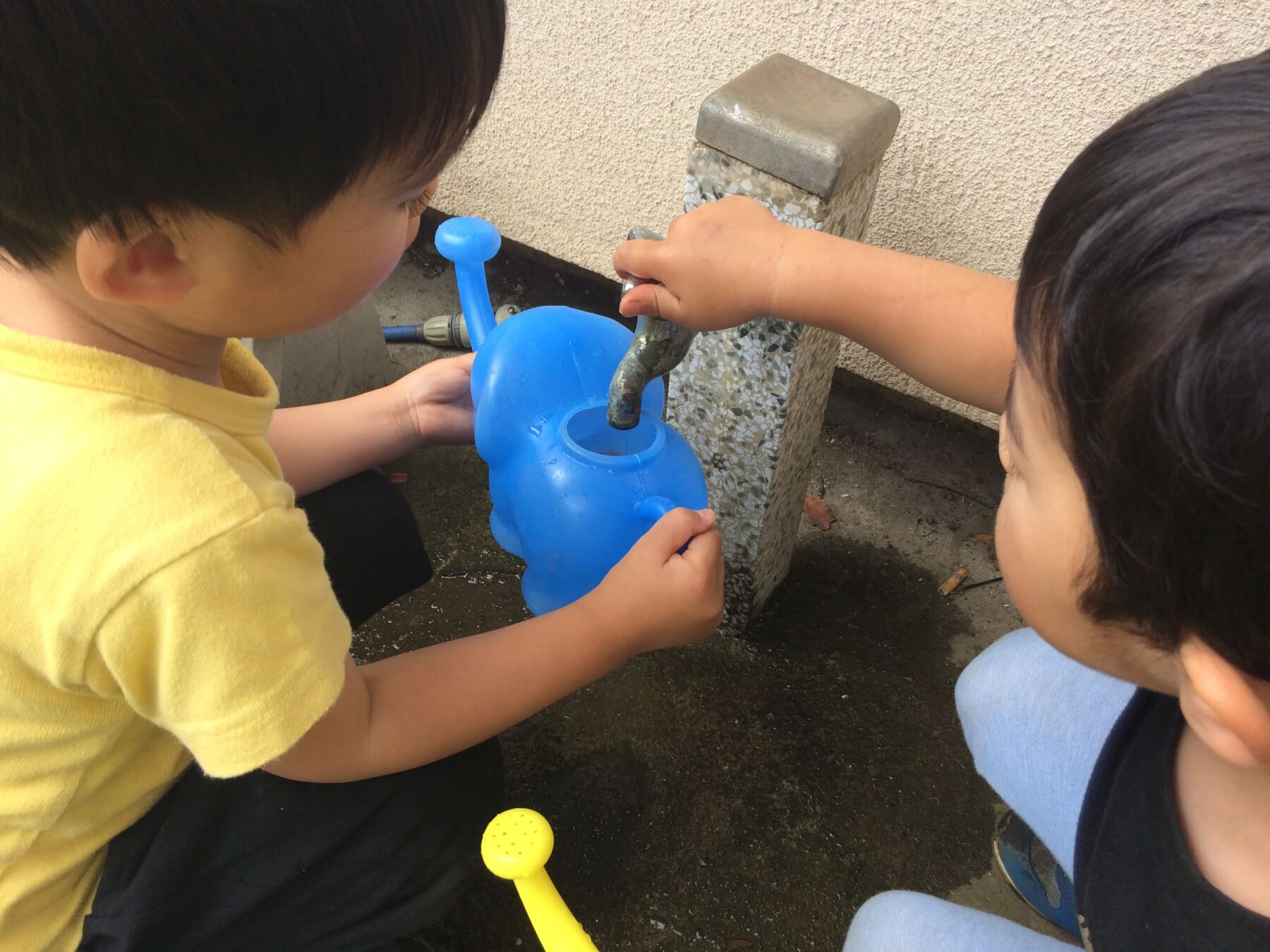 ジョウロにお水を入れる子供達