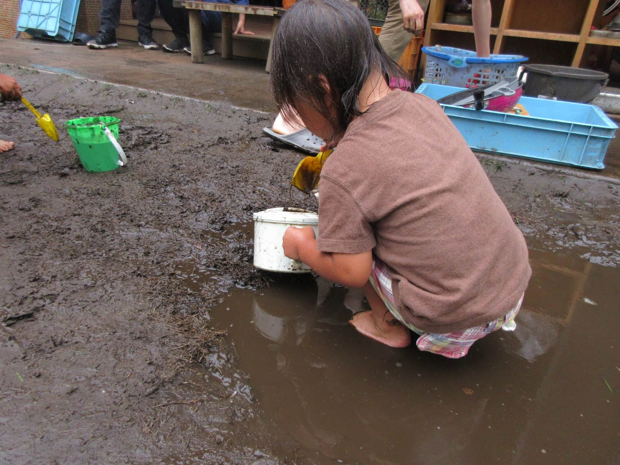 どろんこ遊びに集中する女の子