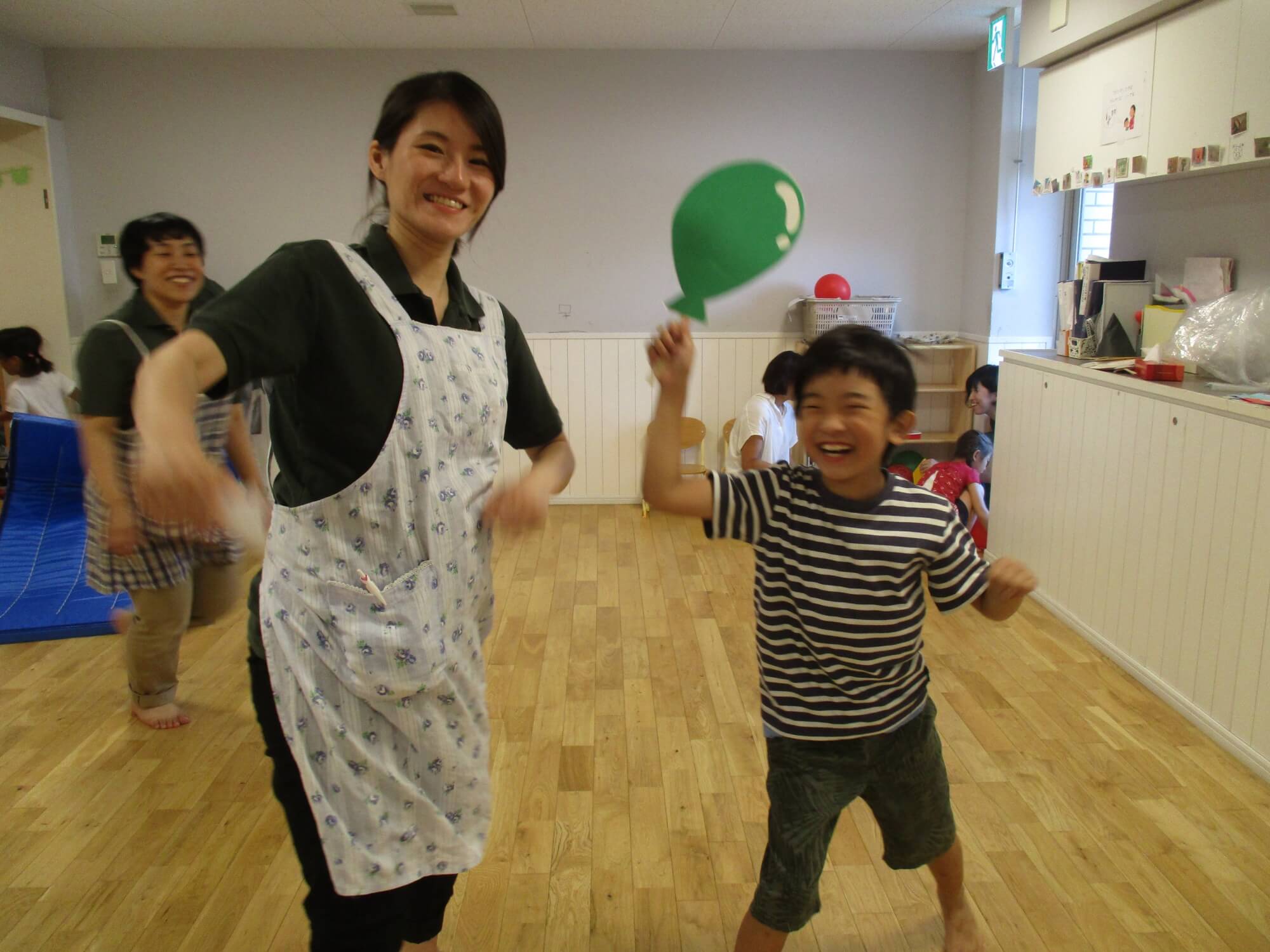 食後の遊びを楽しむ子どもと職員