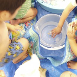 氷水のバケツに手を入れる子ども