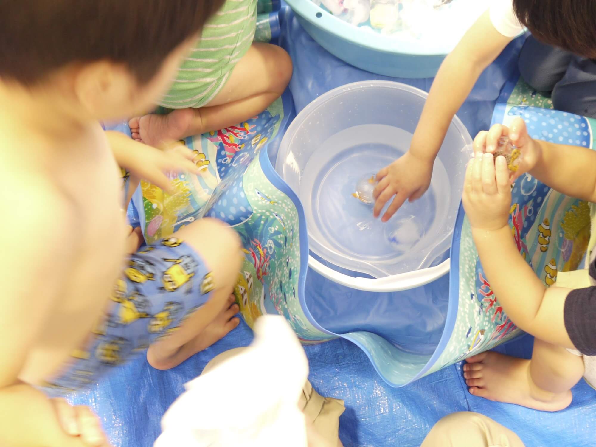 氷水のバケツに手を入れる子ども