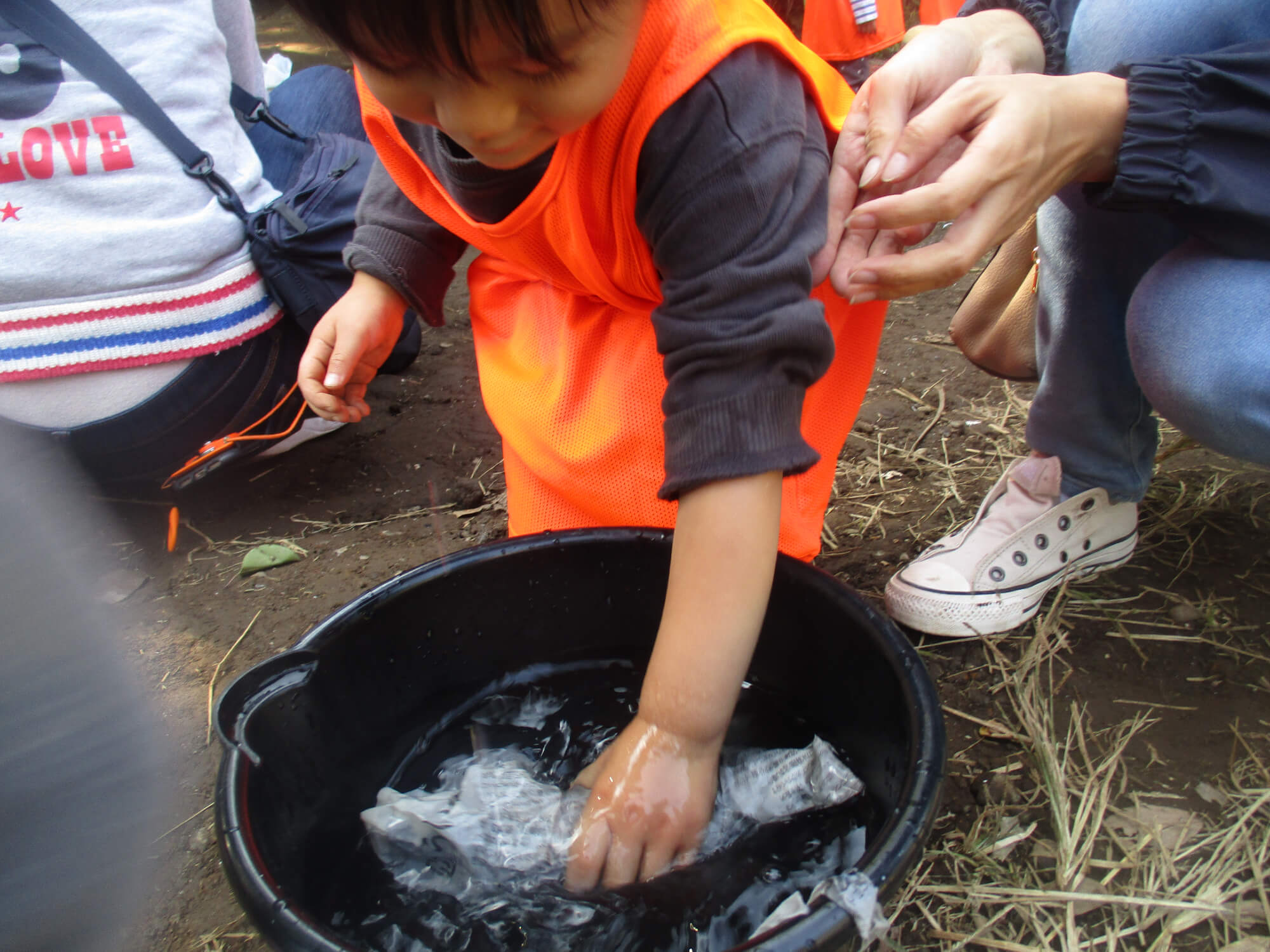 さつまいもを水に濡らす子ども