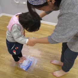 うどんの素を足で踏む子ども