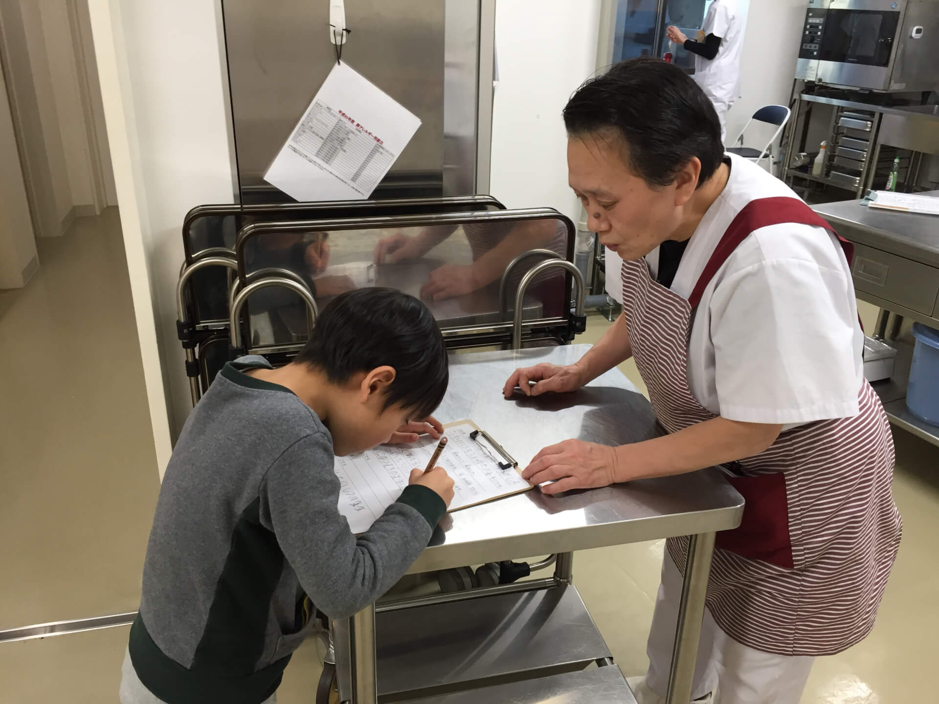 給食室でインタビューするこども