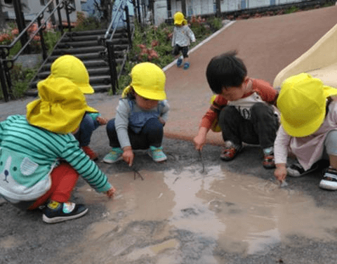 水たまりで遊ぶ子どもたち