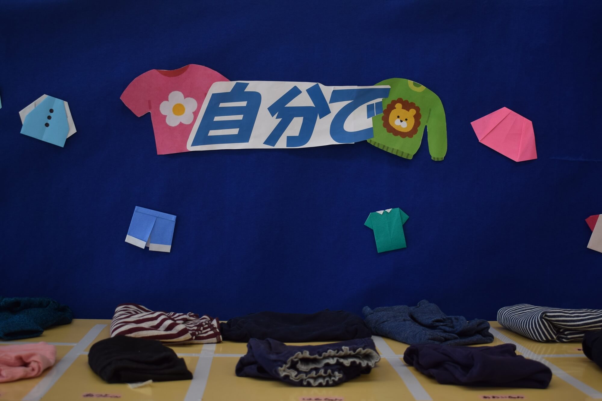 子どもたちが実際に畳んだ服の展示。名前も添えられていました