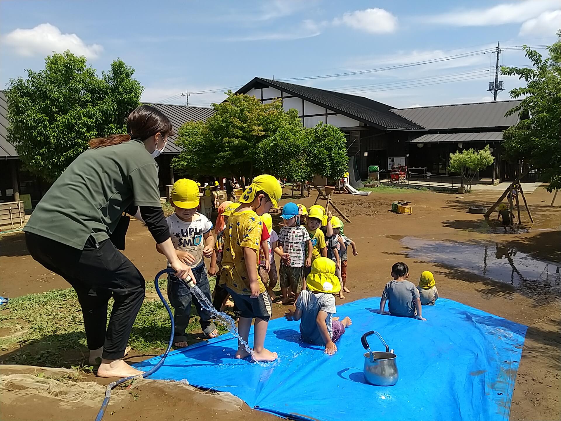 築山でスライダー遊びをする子どもたち