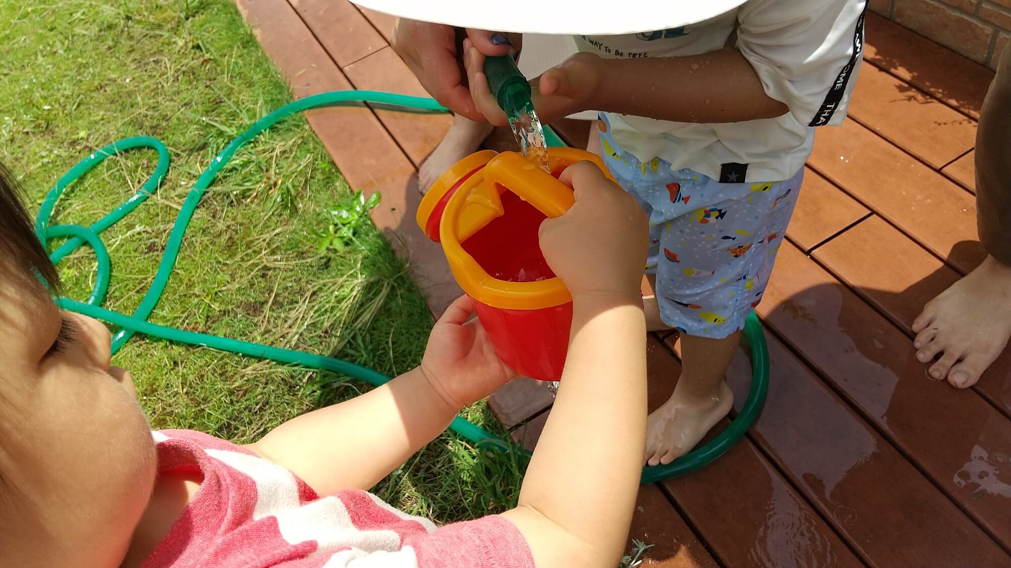 じょうろに水を入れる子どもたち