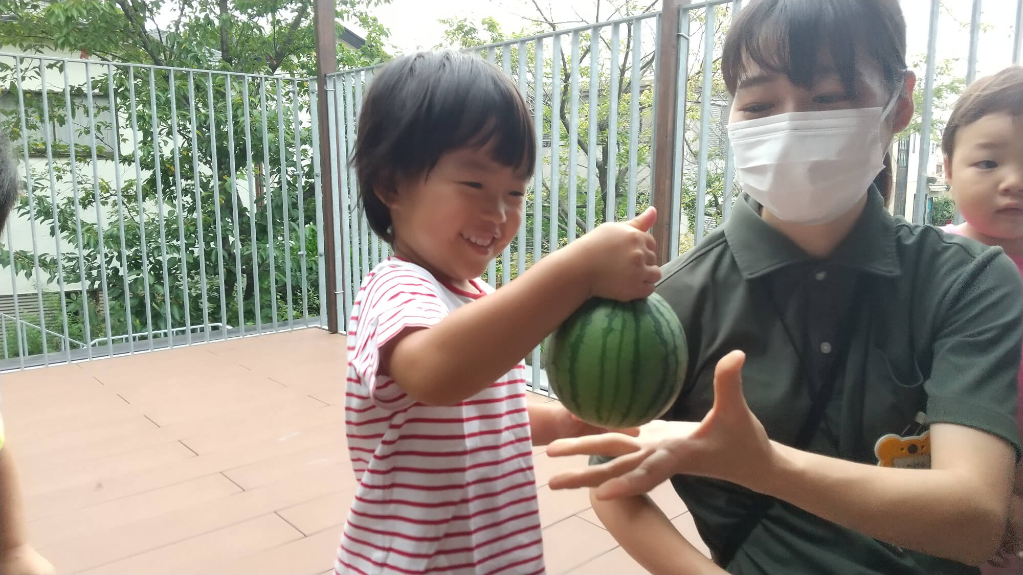 嬉しそうにすいかを持つ子ども