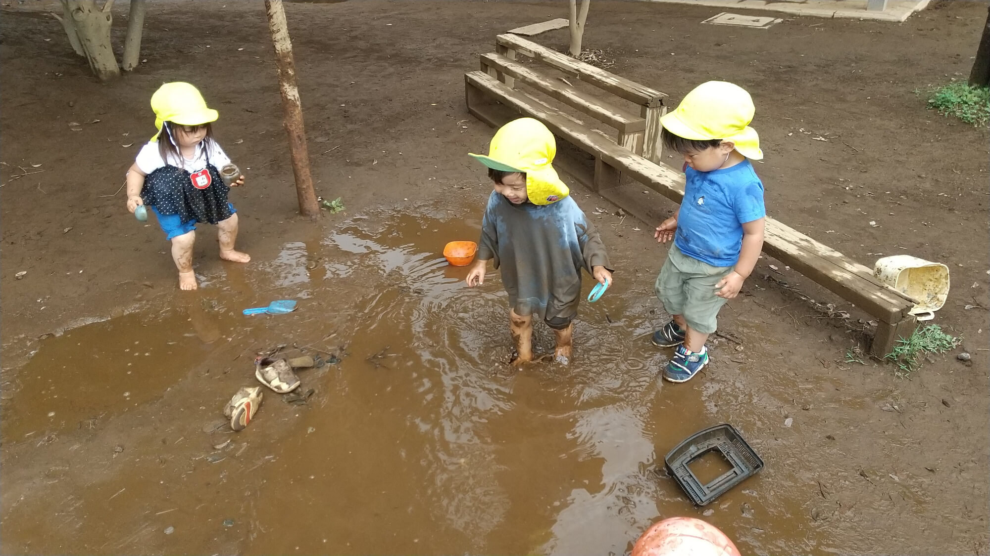 水たまりで泥遊びを楽しむ子どもたち