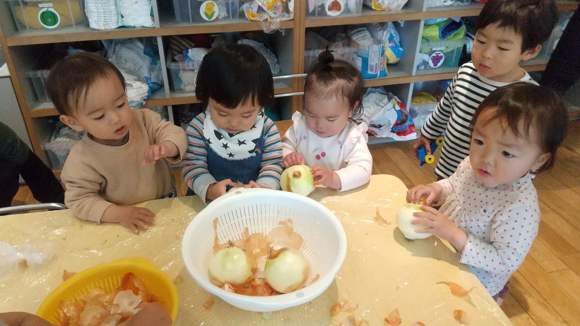 玉ねぎの皮むきをする子どもたち