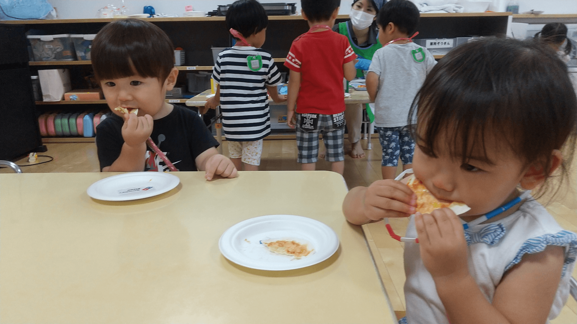 焼きあがったピザを食べる子どもたち