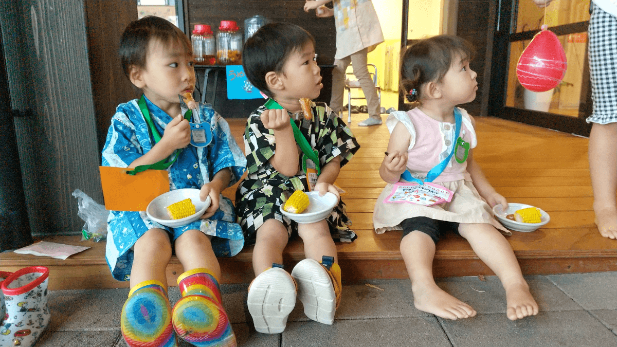 とうもろこしを食べる子どもたち