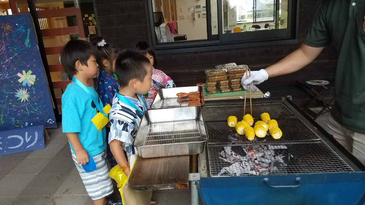 焼きとうもろこしを待つ子どもたち