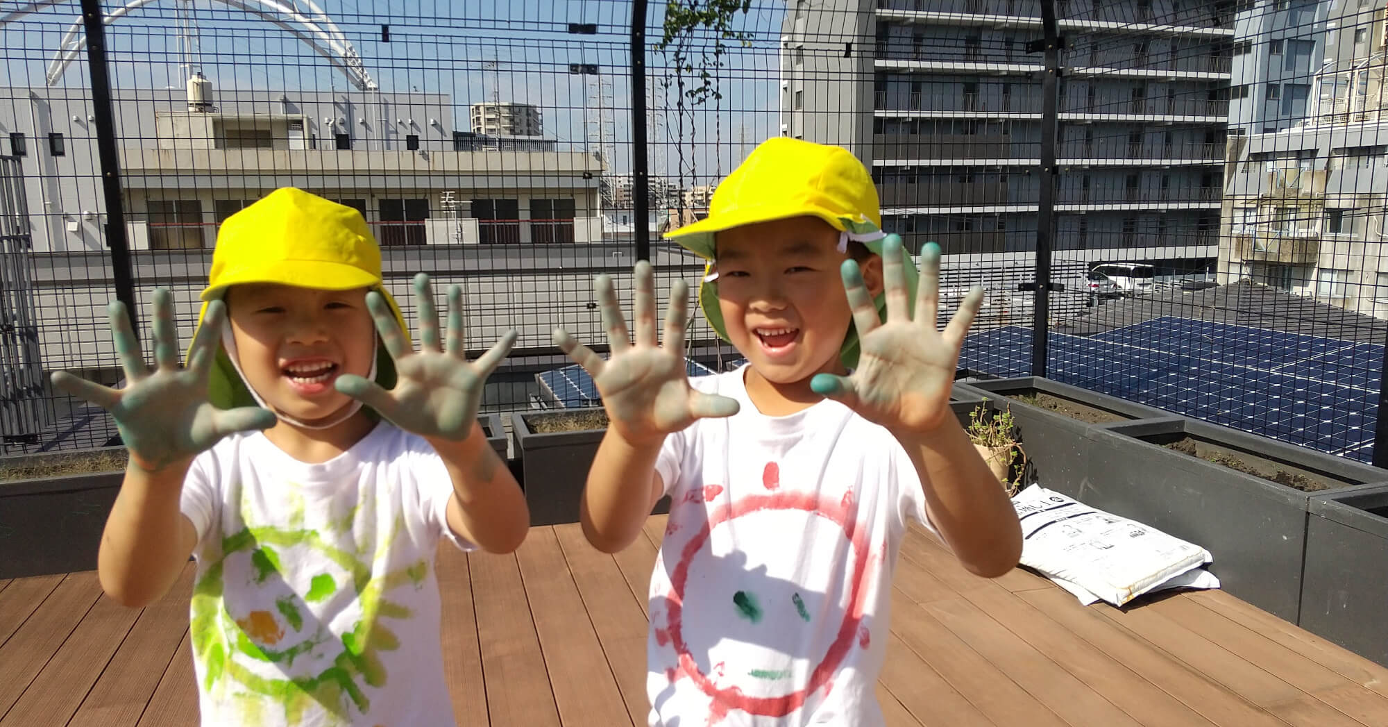 しぼり染めで汚れた手を見せる子どもたち