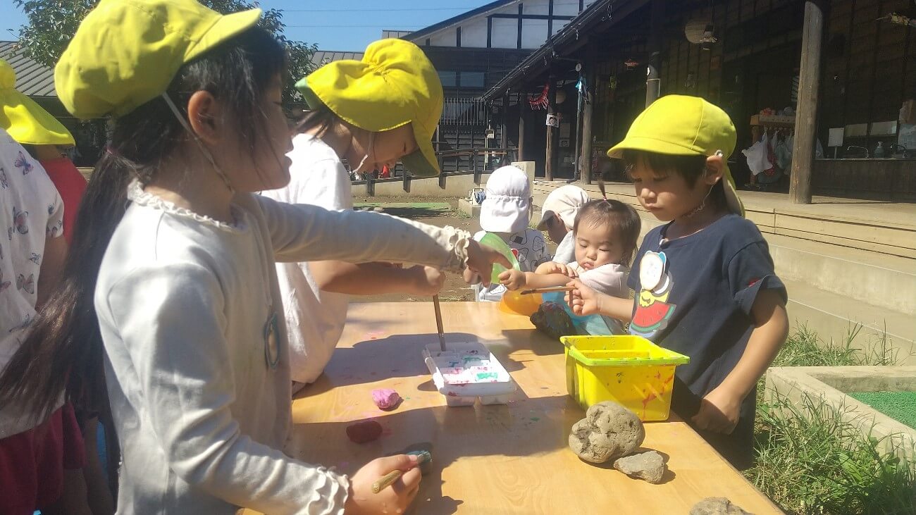 石に色を塗る子どもたち