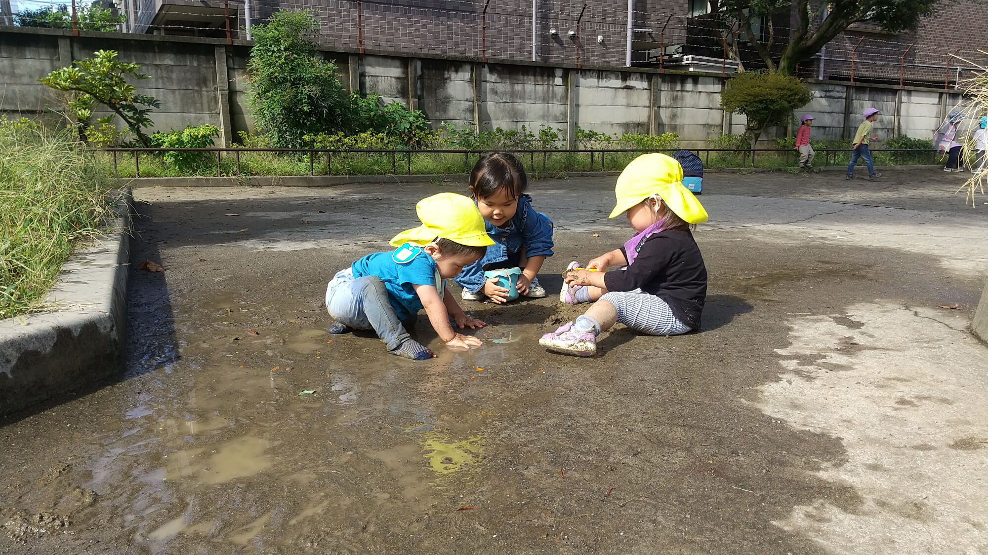 雨上がりに水たまりで遊ぶ子どもたち