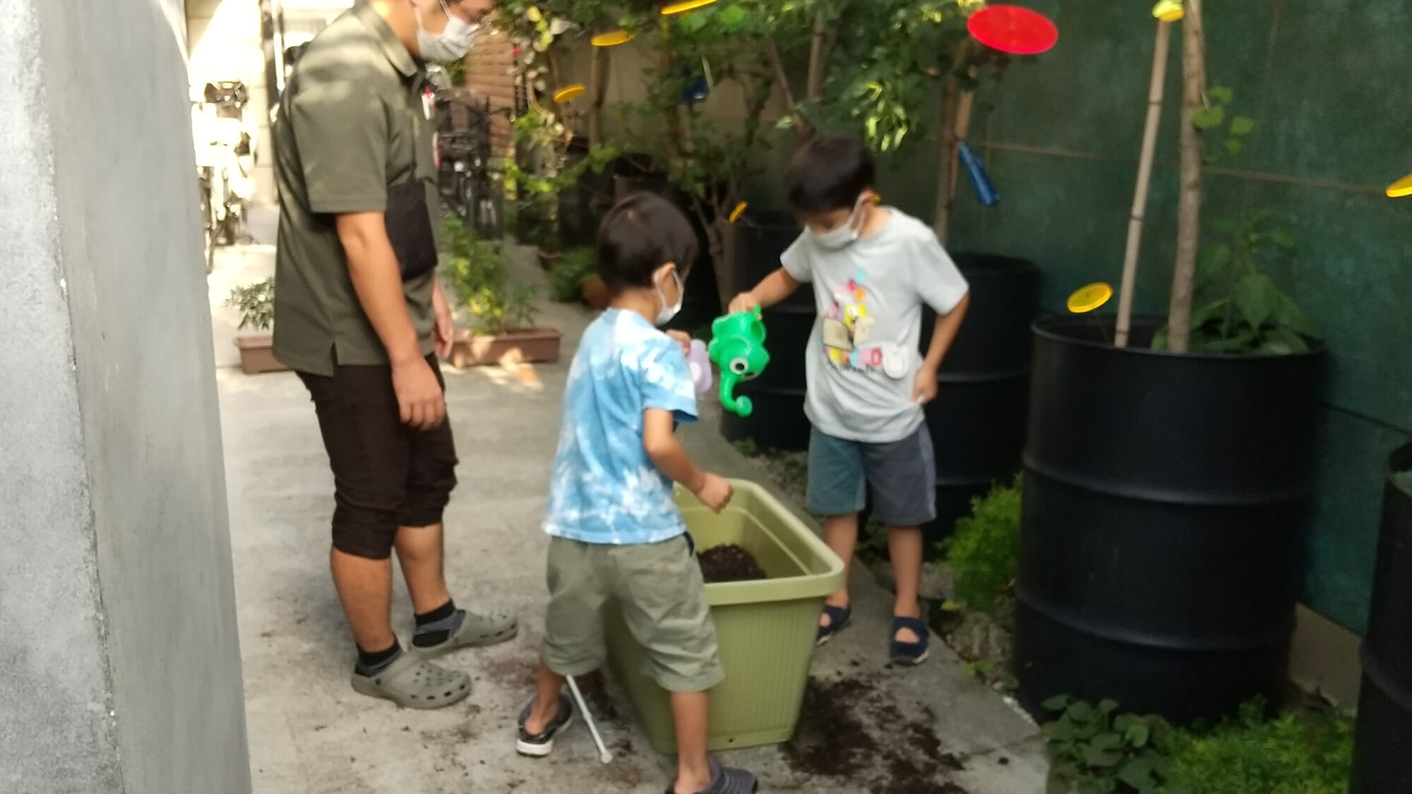 プランターに水やりをする子どもたち