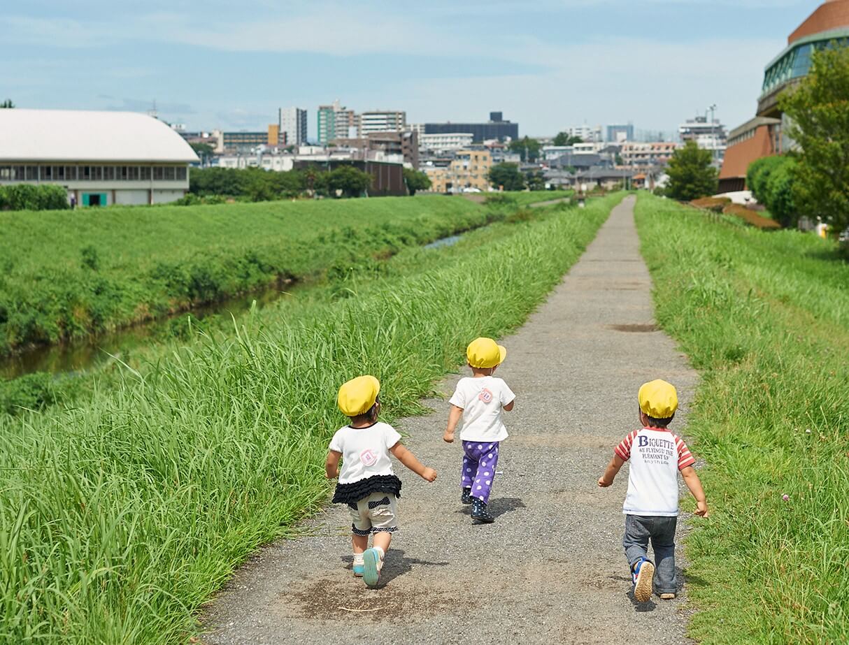 川の土手を散歩する子どもたち