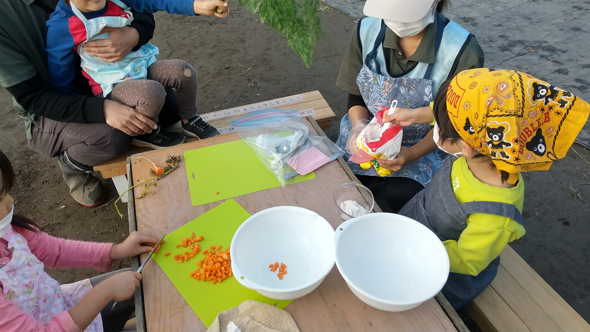 計量カップで小麦粉を計る子ども