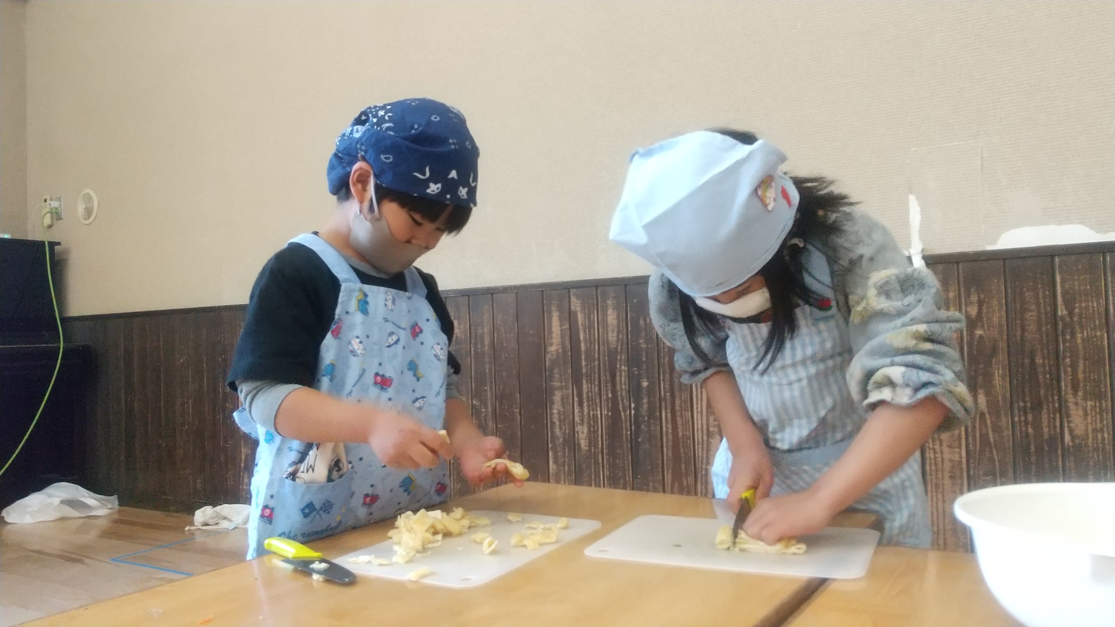 包丁を使って食材を切る子どもたち