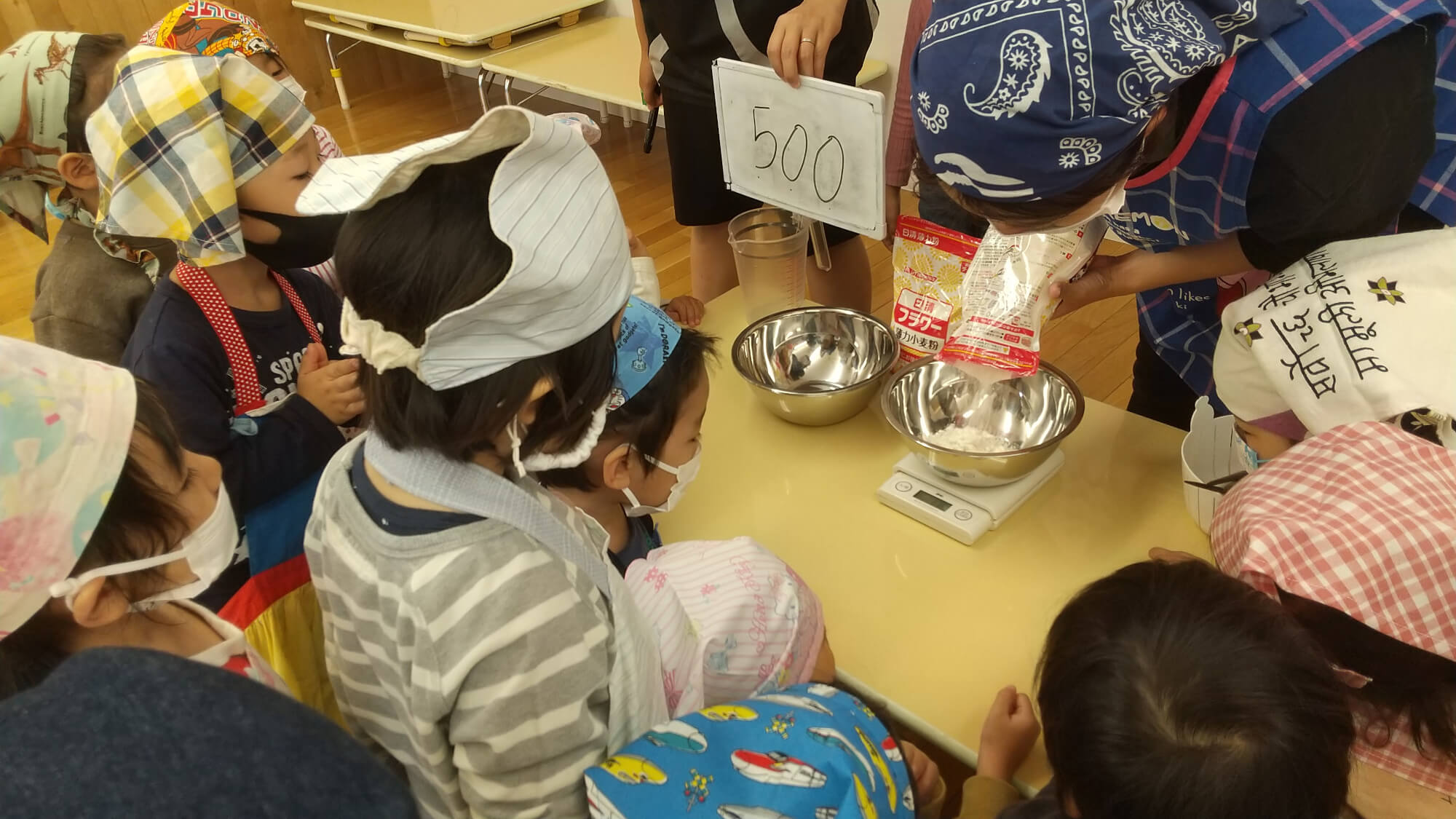 小麦粉の重さを量る子ども