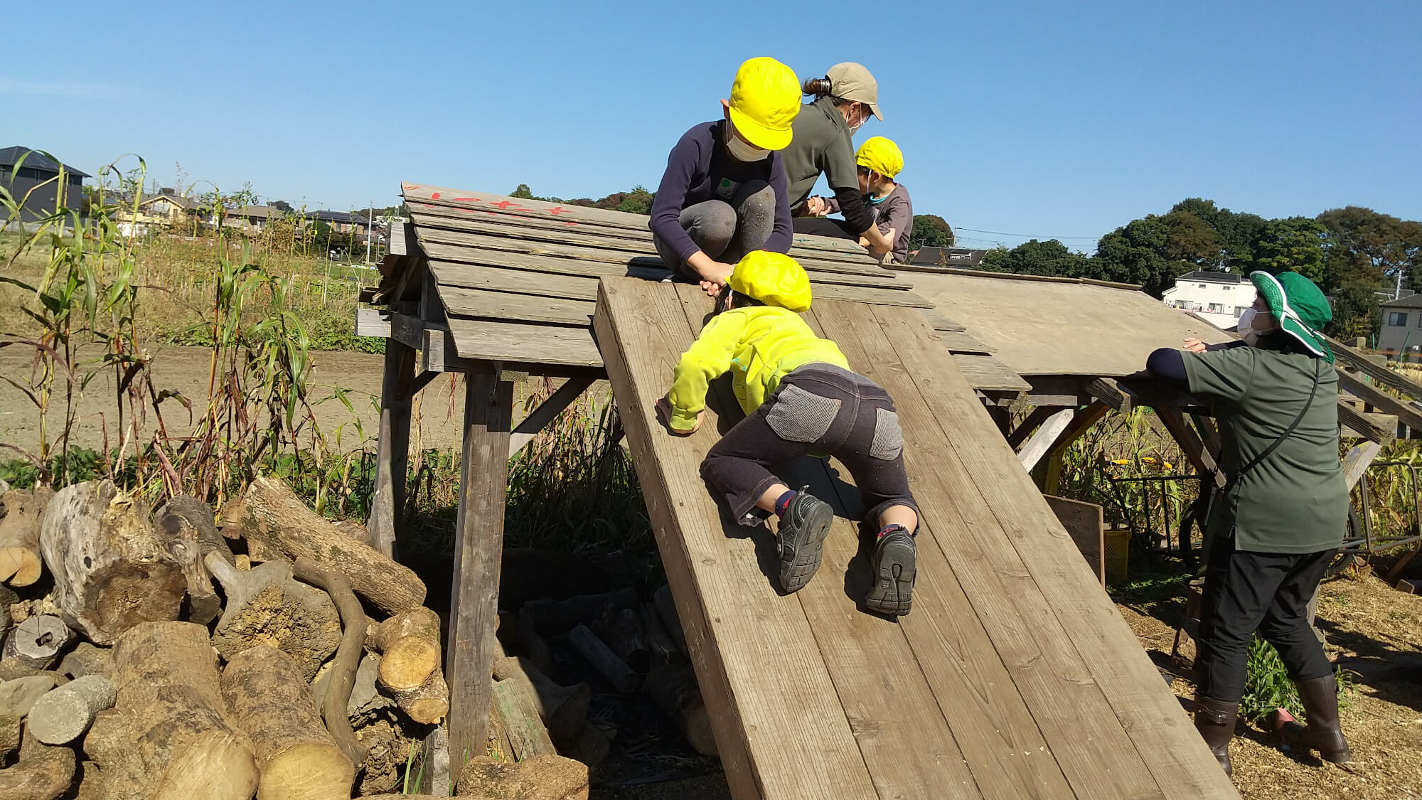 掘っ立て小屋の屋根の上に登る子どもたち