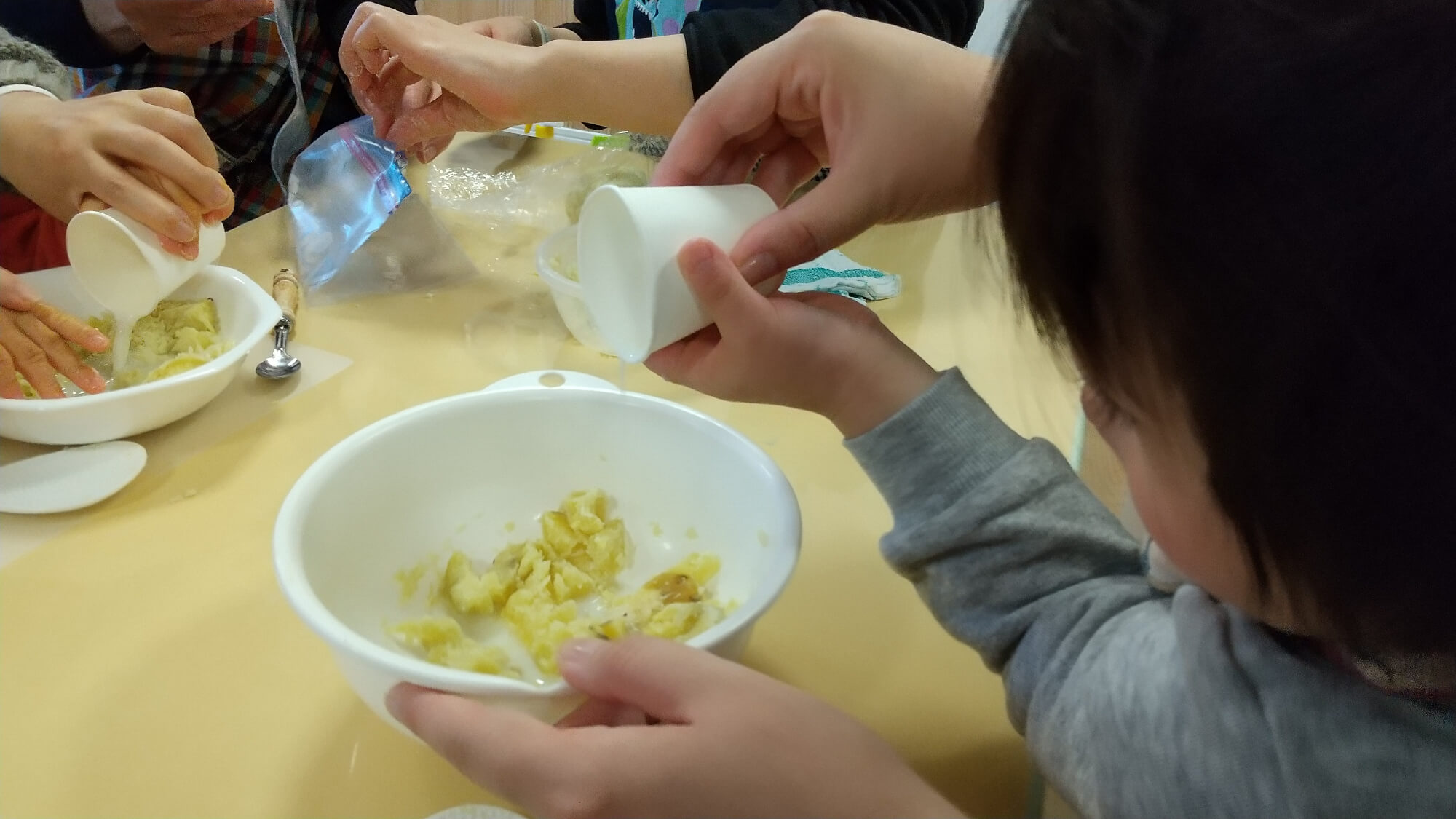 ボールに材料を入れる子ども