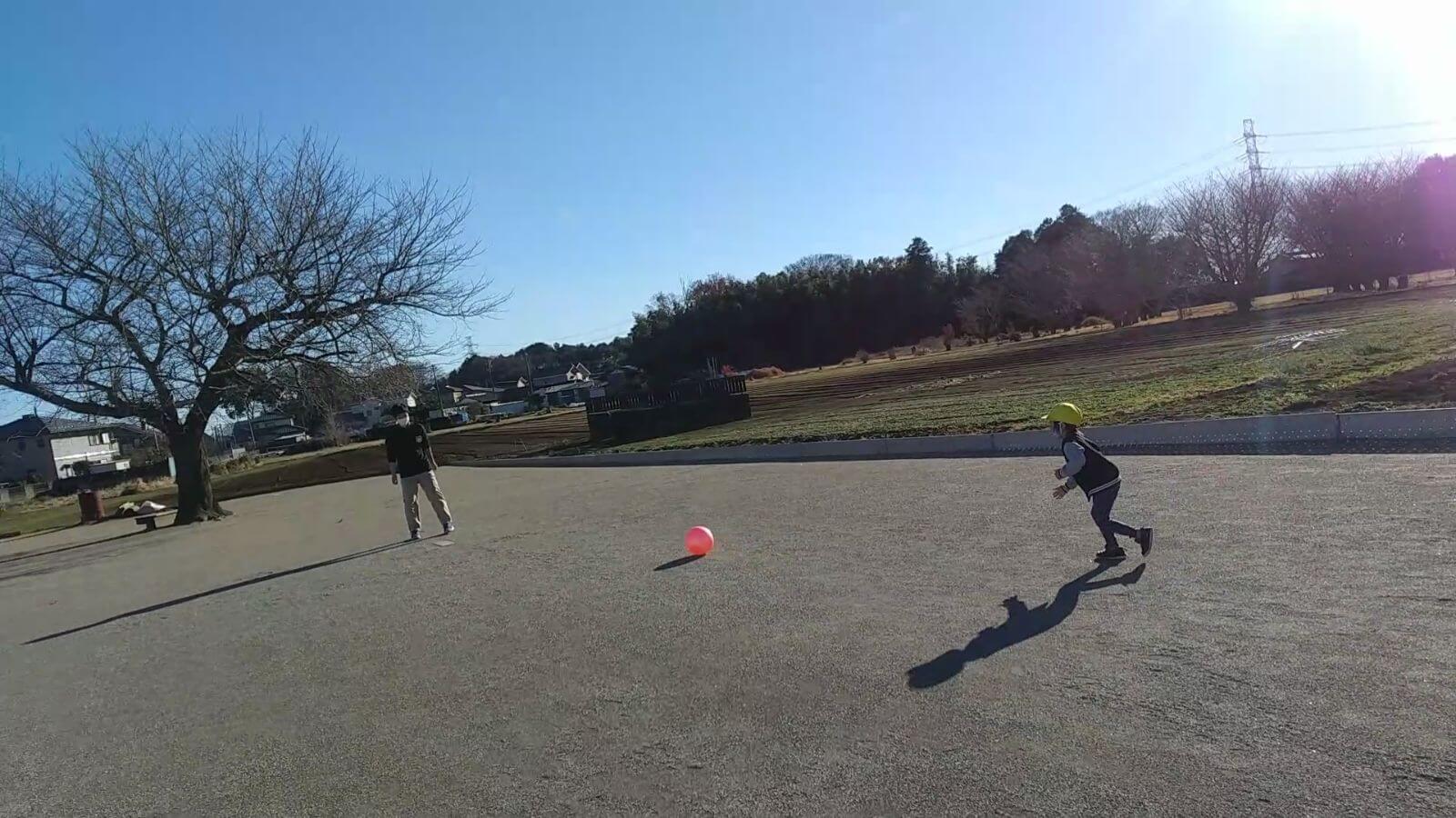 グラウンドでボール遊びをする子ども