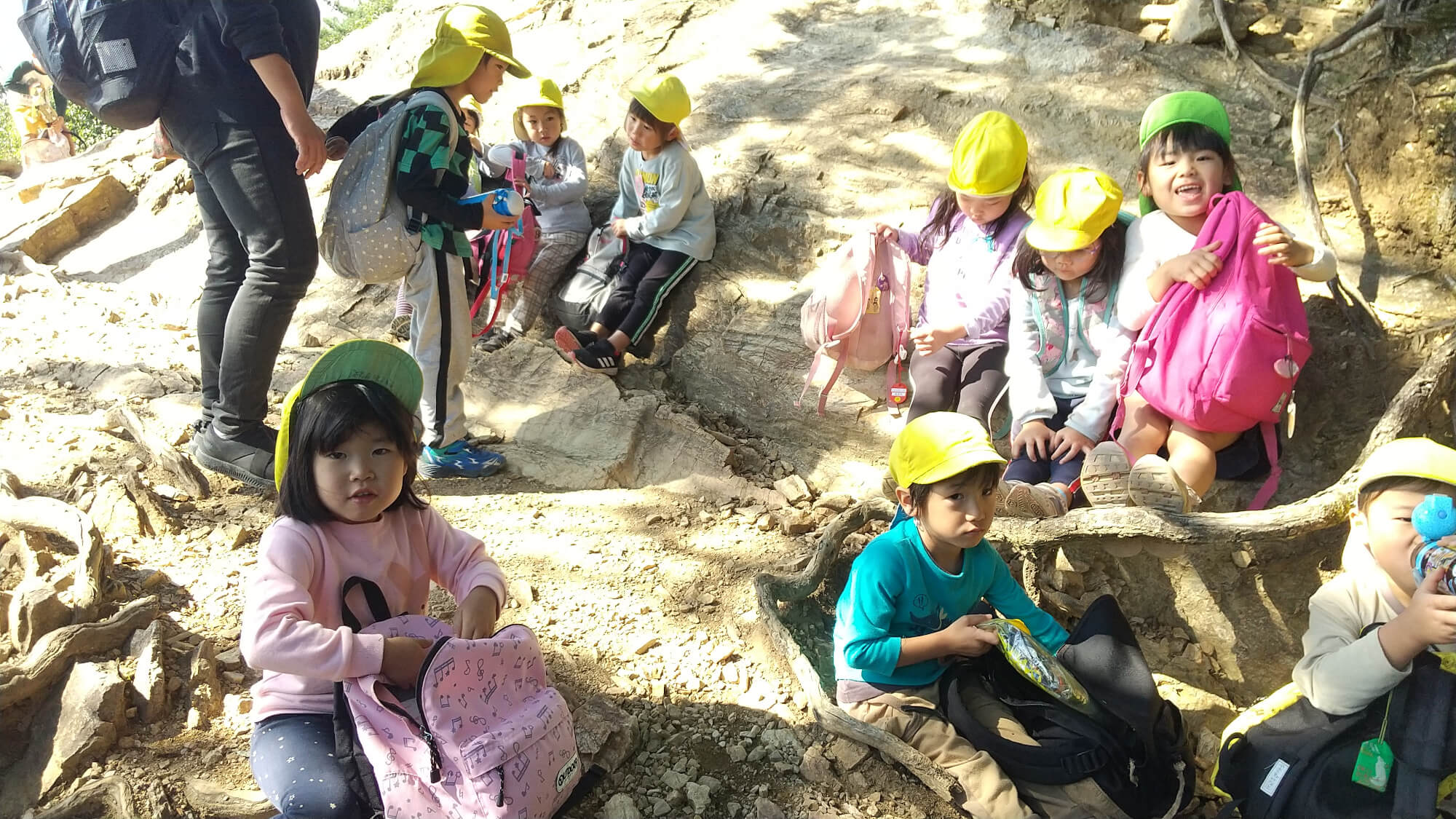 頂上で水分補給をする子どもたち