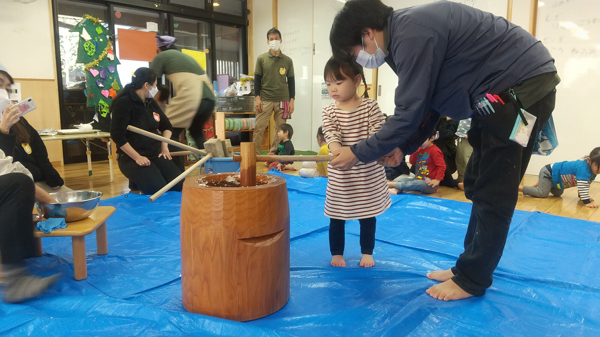 保育者と遺書に餅つきをする子ども