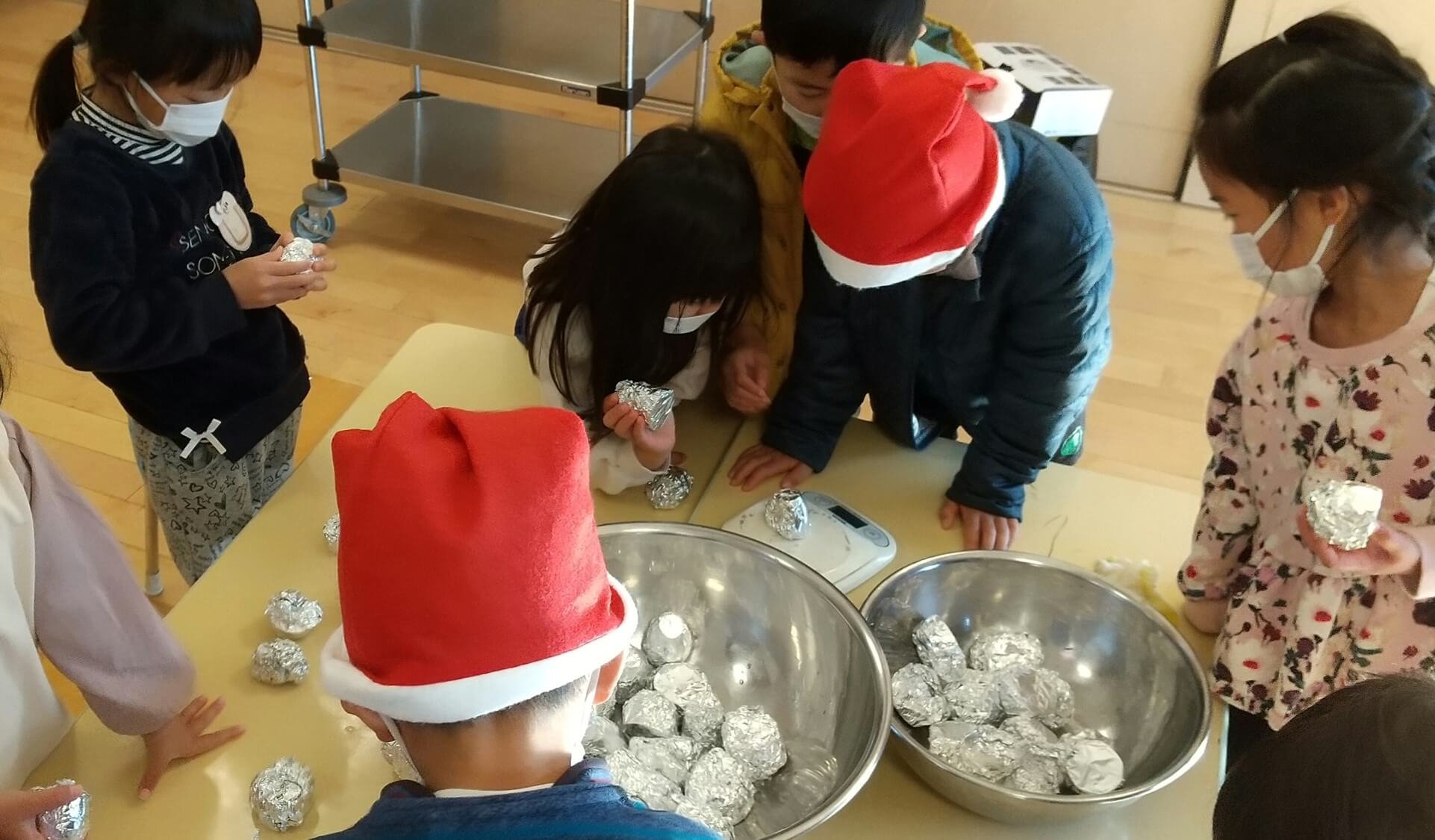 切ったさつまいもを計量器で量る子どもたち