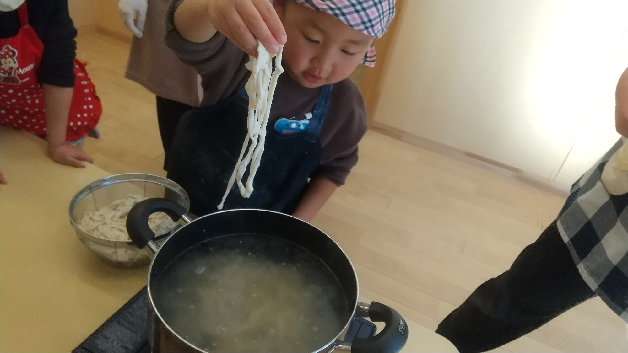 うどんを鍋でゆでる子どもたち