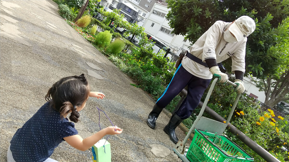 餌箱を地域の方に見せる子ども