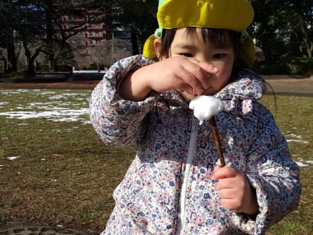 雪のお団子を作る子ども