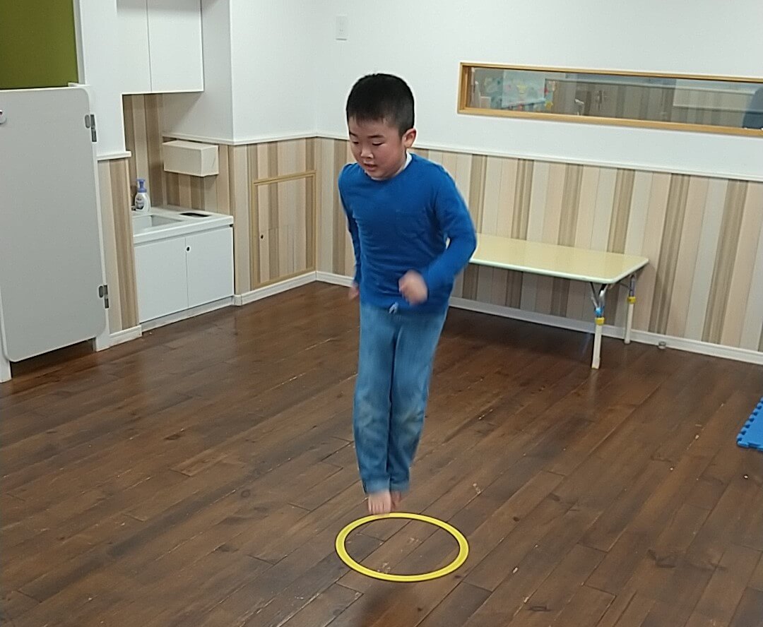 円から出ないように上にジャンプをする子ども