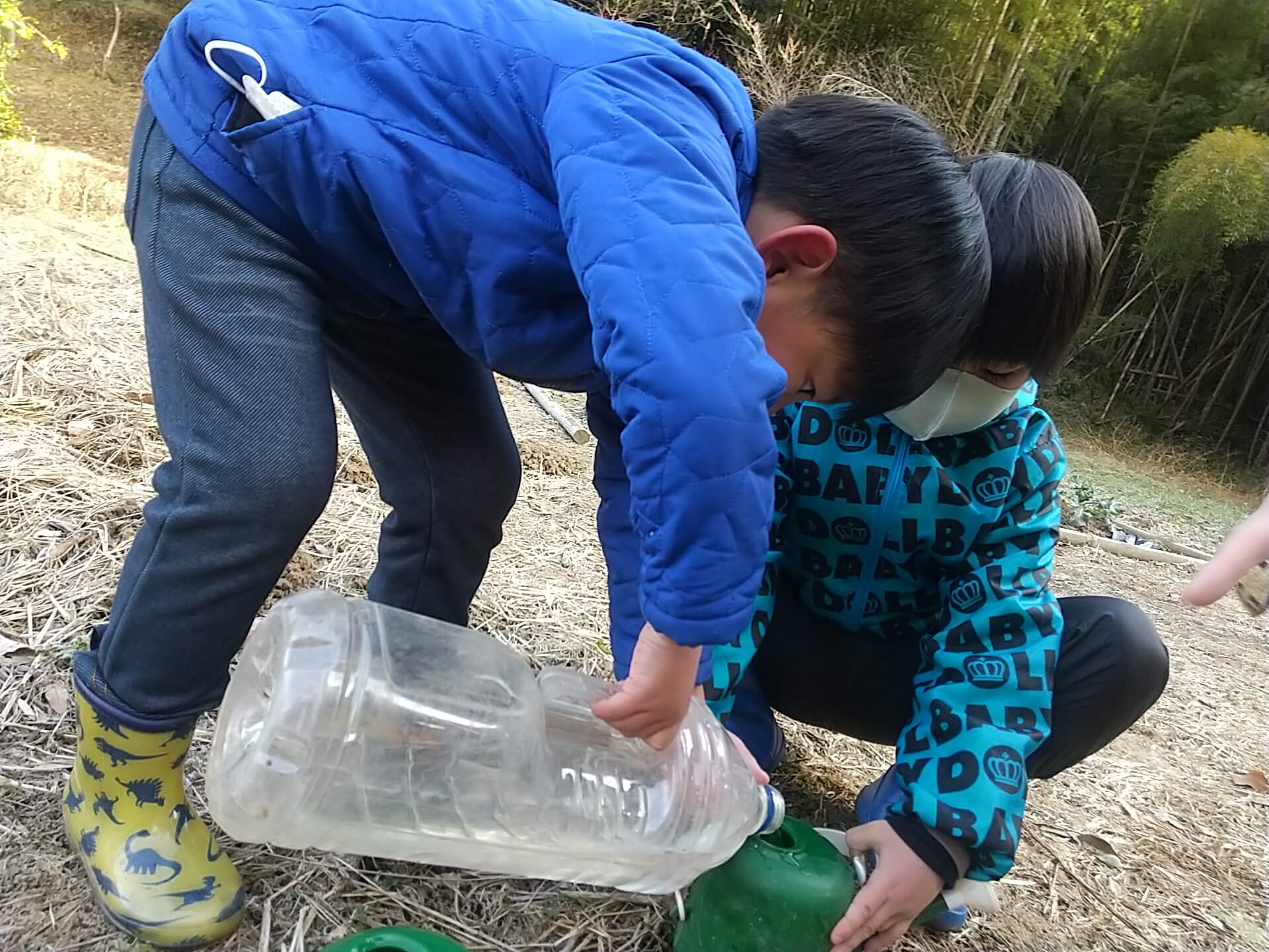 水をじょうろに注ぐ子どもたち